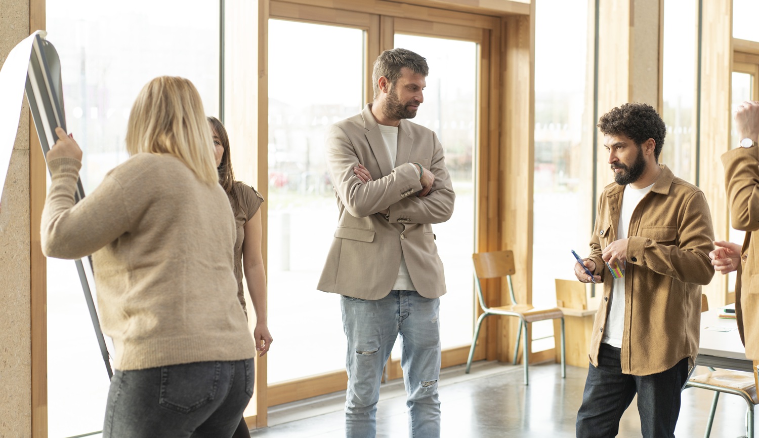 Animation d'un coaching d'équipe, format long, par l'organisme de formation Homan. Des participants sont autour d'un paper board et réfléchissent ensemble à des idées, en intelligence collective
